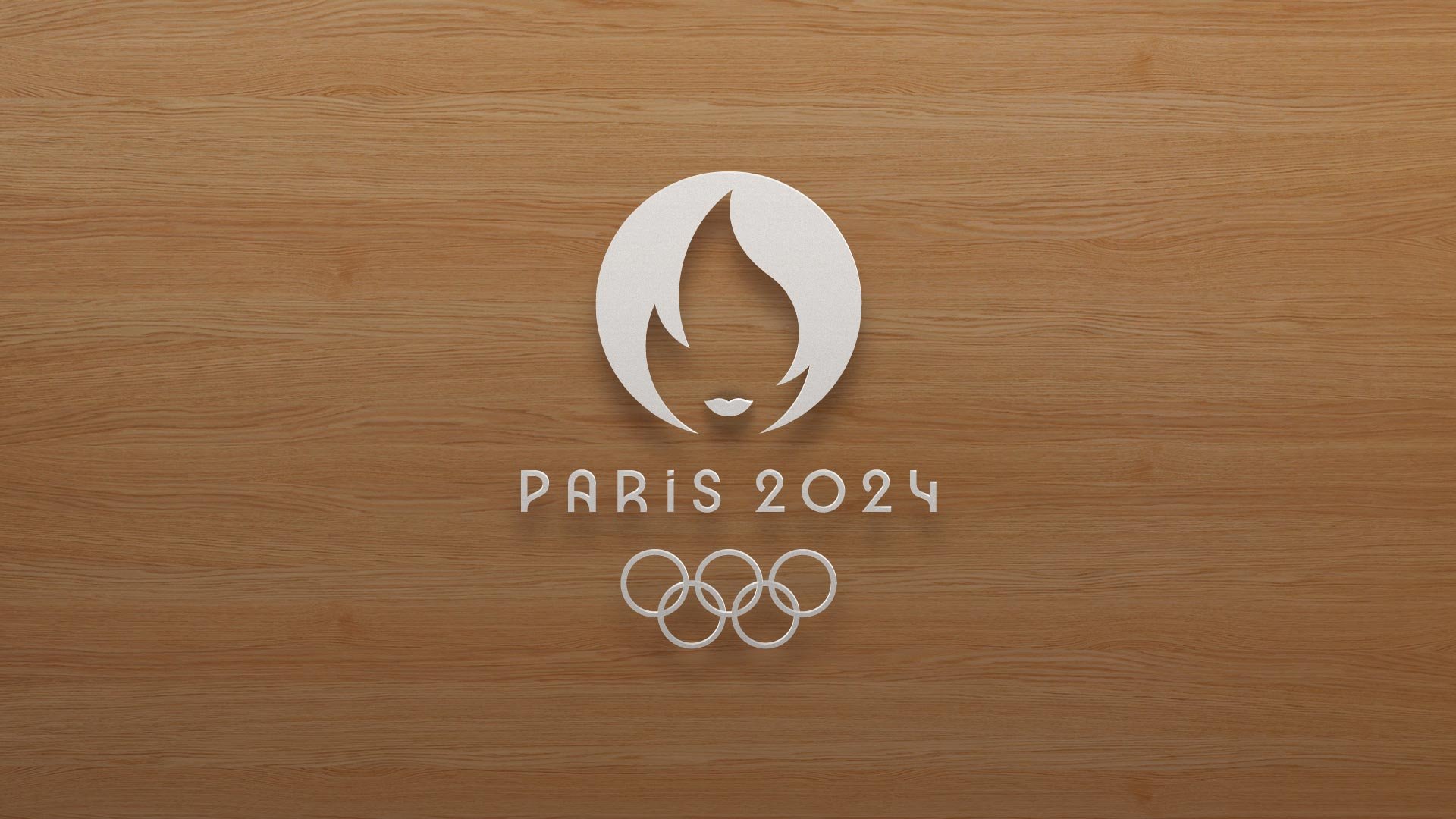 Logo des JO Paris 2024 en blanc sur un support en bois